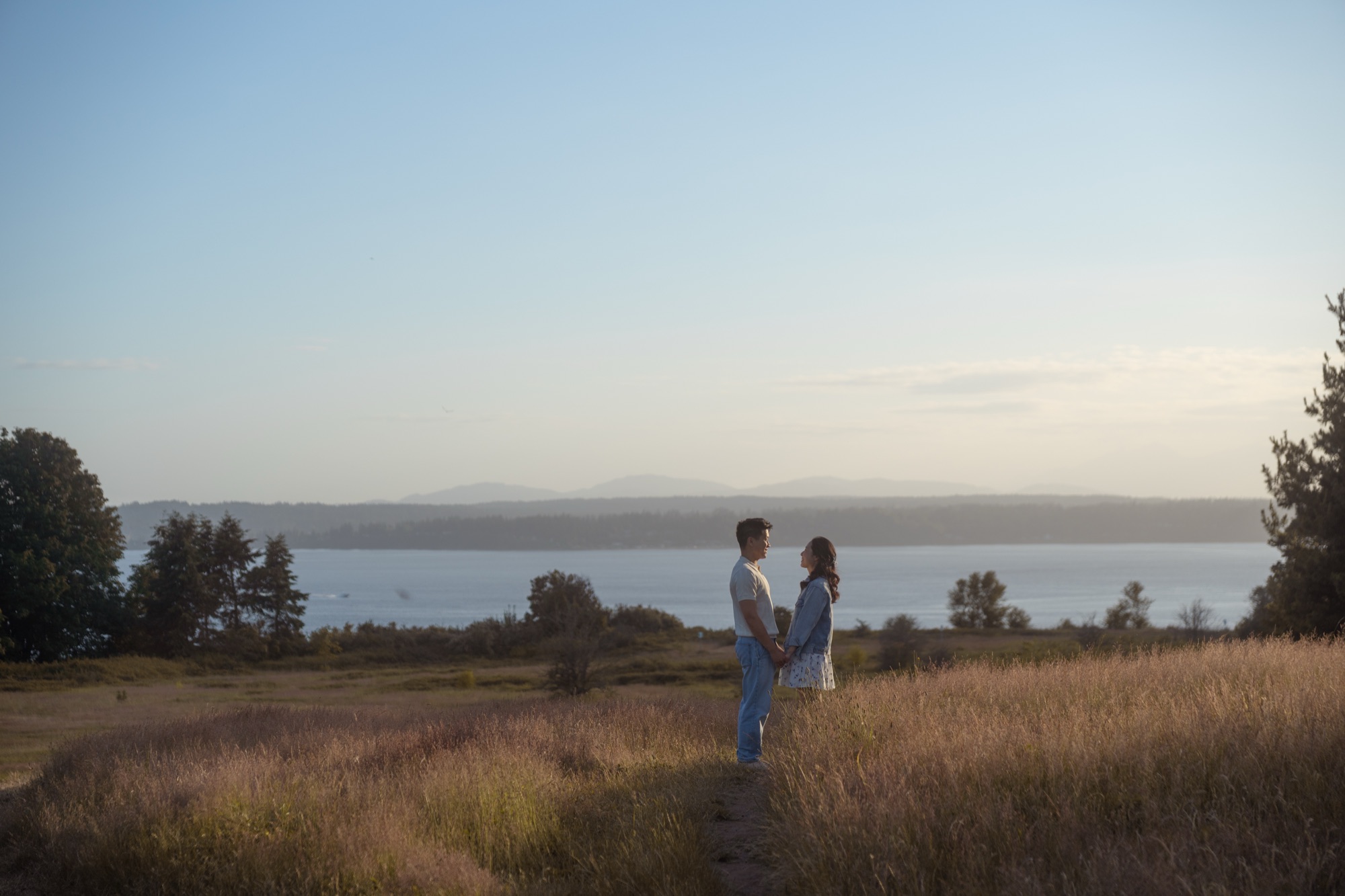 Matthew and Tiffany in a field above the water at Discovery Park